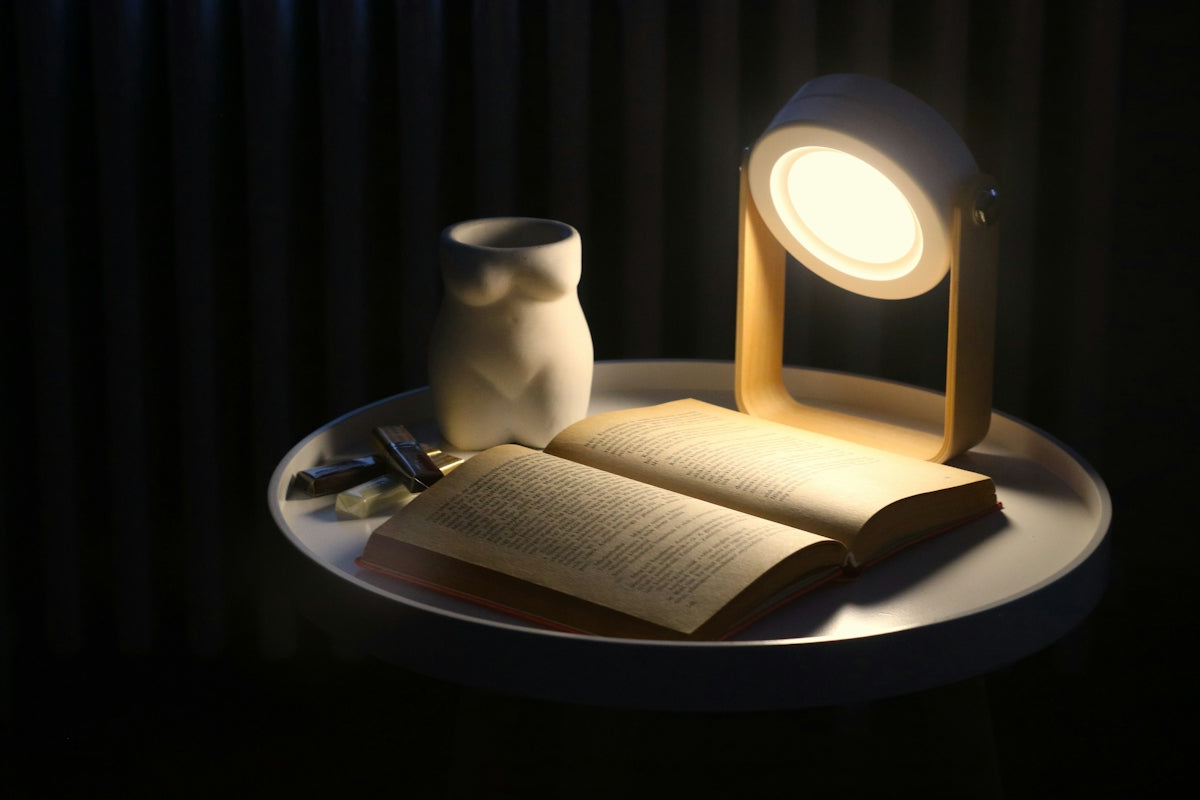 An open book and a lamp on a table